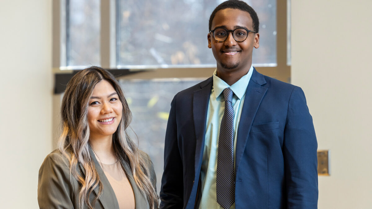 Two students in formal attire smiling.